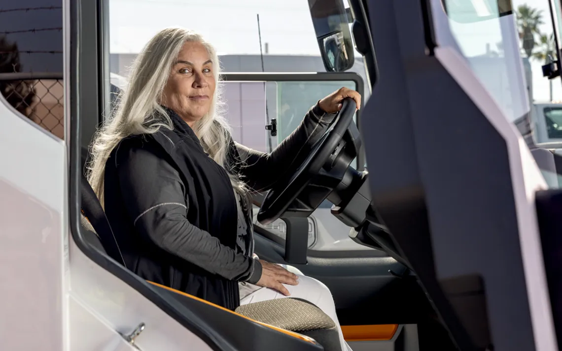 Lisa McGhee looks sideways at the camera from the driver seat of a truck