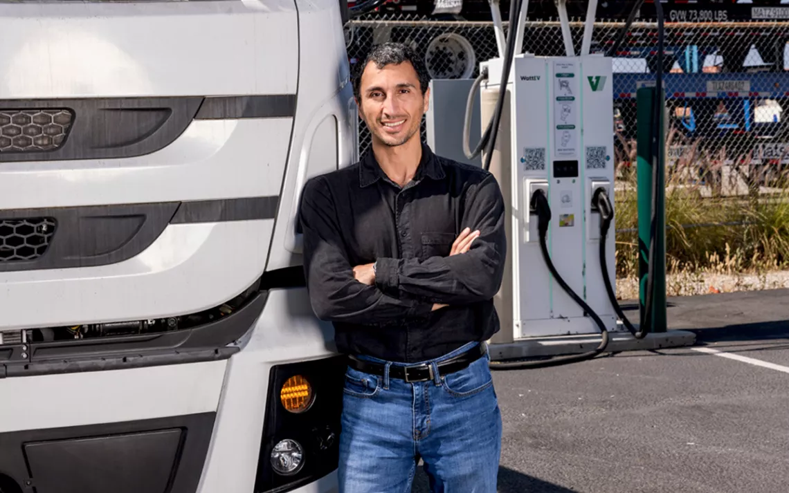 Salim Youssefzadeh wears jeans and black shirt and leans against a white truck