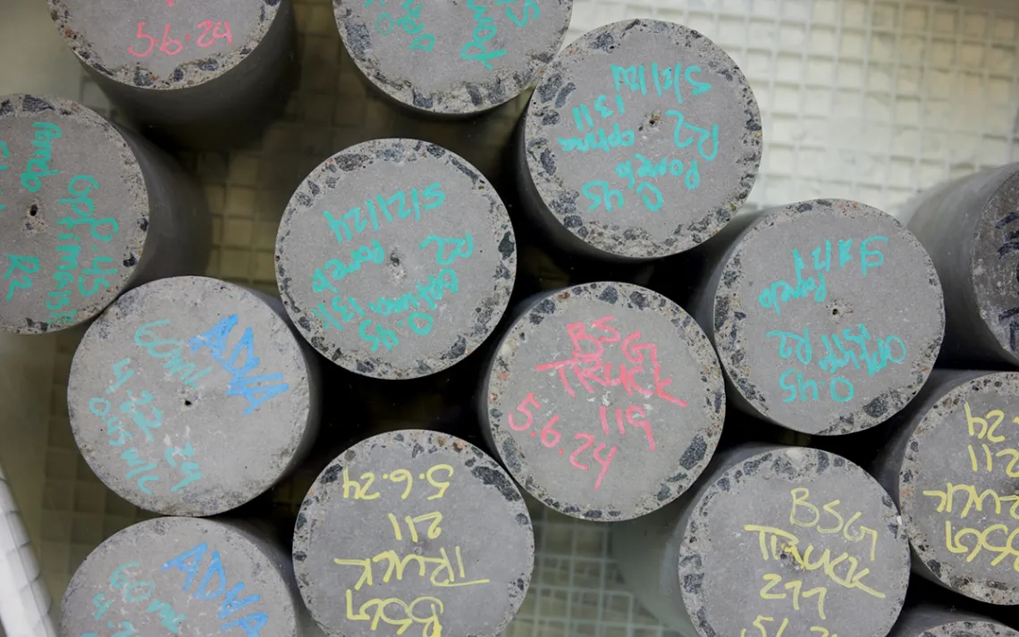 Cylinders of cement samples with various notations written on the top