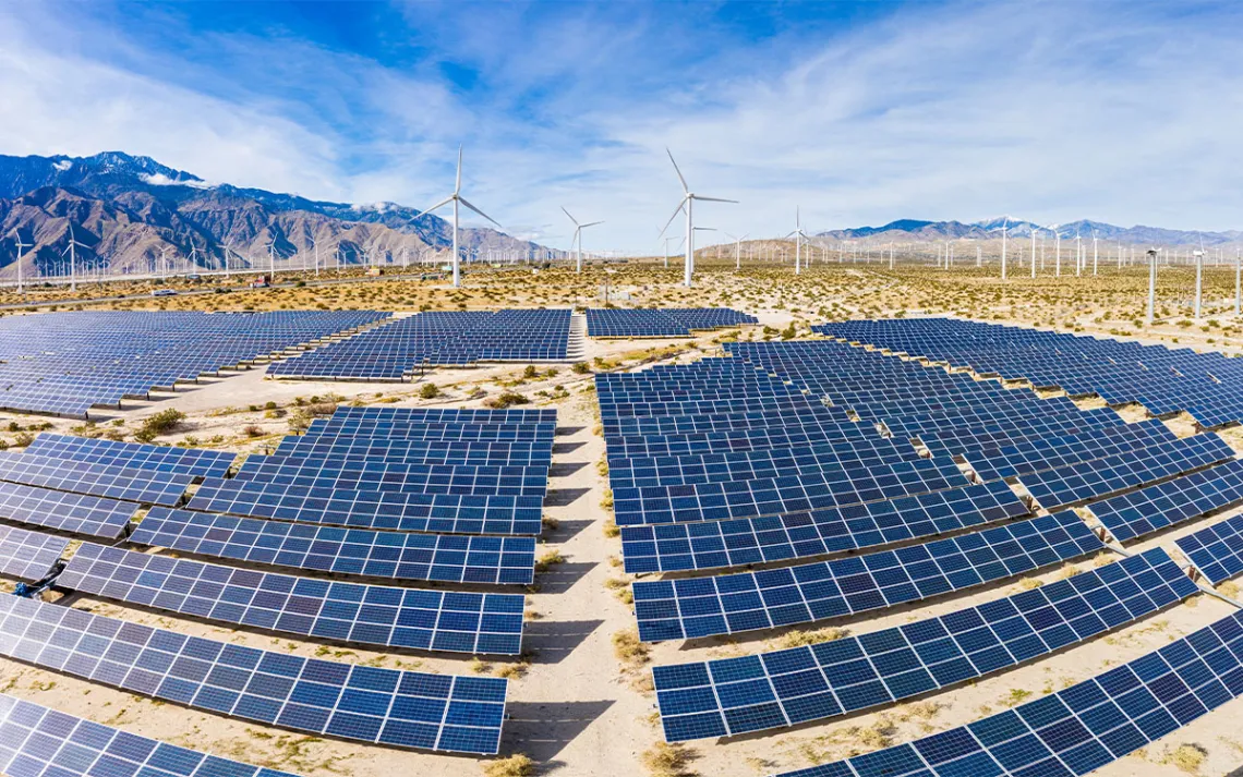 A field of solar panels and windmills in the desert. | Photo by adamkaz/Getty Images