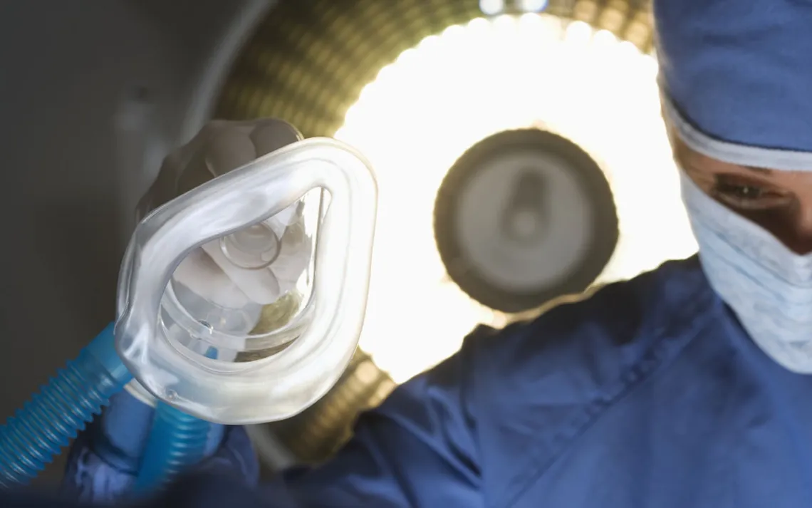 A doctor holds a nebulizer mask in an operating room
