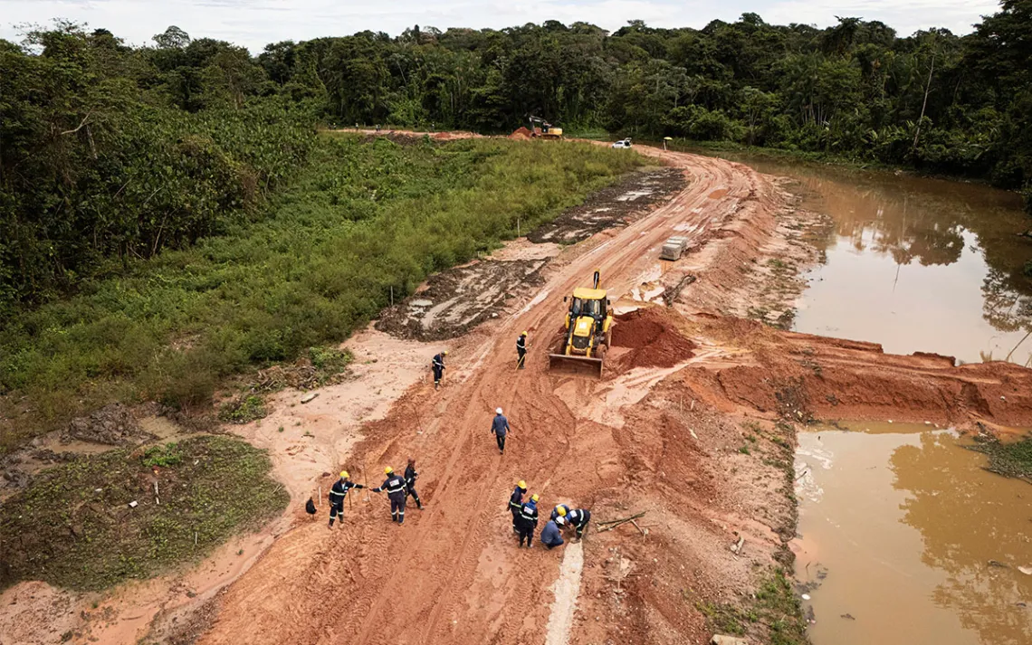 A muddy road under construction in a rainforest 