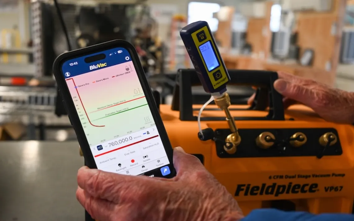 Dave Whittemore works in Kennebec Valley Community College’s heat pump lab, where he teaches students how to install and maintain electric heat pumps, which are growing in popularity across Maine. Photo by Kristian Moravec.