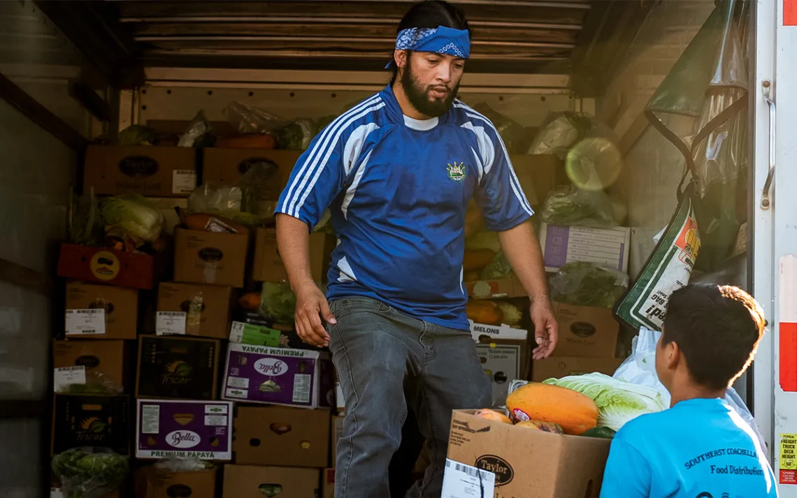 Volunteers fill a U-Haul full of cartons of fresh produce to be delivered to local trailer parks.