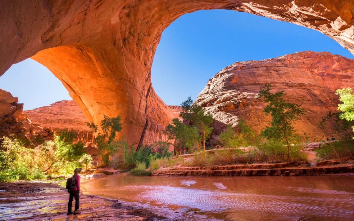 A hiker at Jacob Hamblin Arch in Coyote Gulch, Grand Staircase-Escalante National Monument, Utah, United States