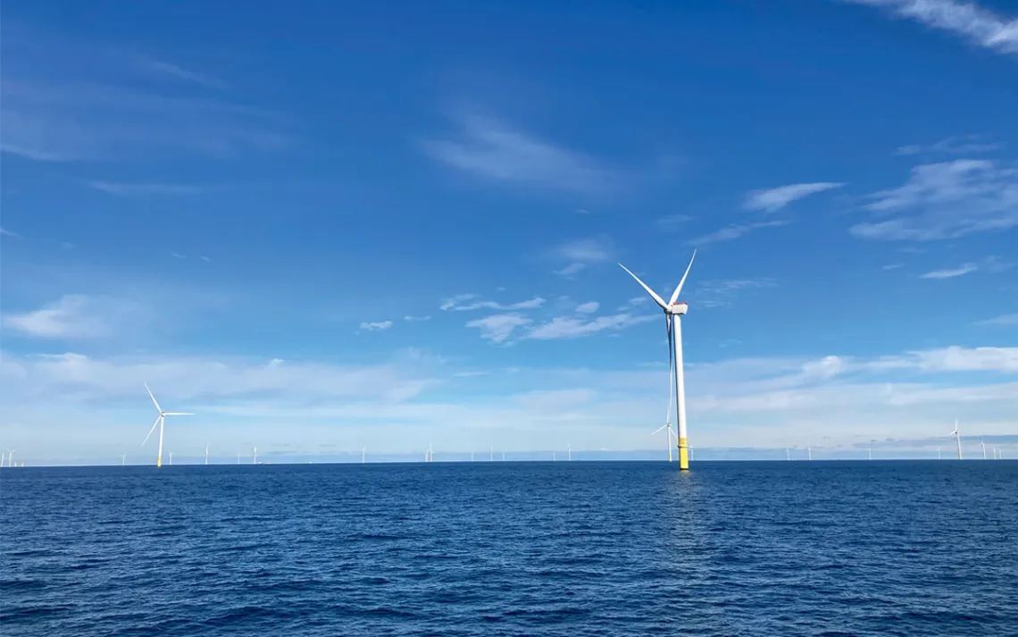 Wind turbines poke out of blue ocean water at the South Fork Wind farm.