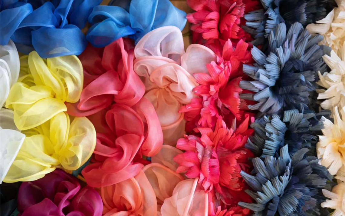 Fashion flowers of a collection lie in a cardboard box in the warehouse of the Steyer artificial flower manufactory. 