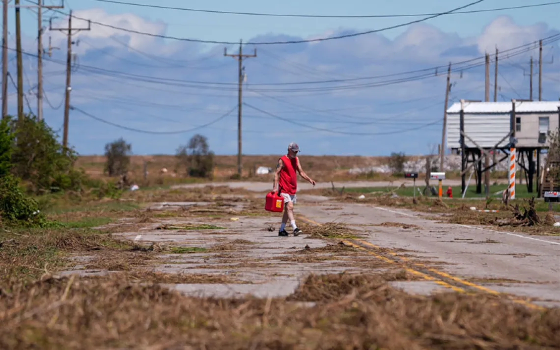 Resident Bill Andrews walks to a store 1.5 miles away to see if he can get gas, after Hurricane Francine flooded his truck, in Cocodrie, La., Thursday, Sept. 12, 2024.  