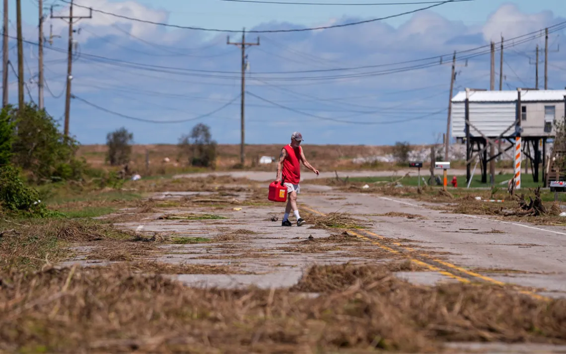 Resident Bill Andrews walks to a store 1.5 miles away to see if he can get gas, after Hurricane Francine flooded his truck, in Cocodrie, La., Thursday, Sept. 12, 2024.  