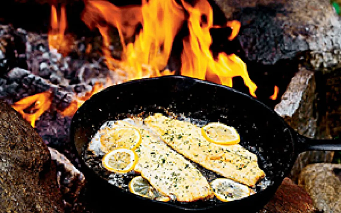 trout cooking over a fire