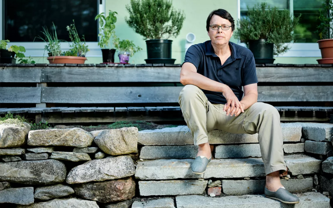 Charles C. Mann sits on the rocky front porch of his house in Amherst, Massachusetts.