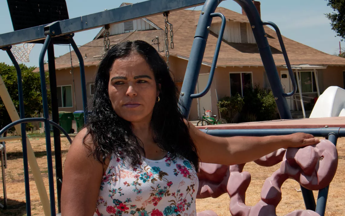 Fidelia Morales in her front yard. The orange groves around her house are frequently sprayed with pesticides. 