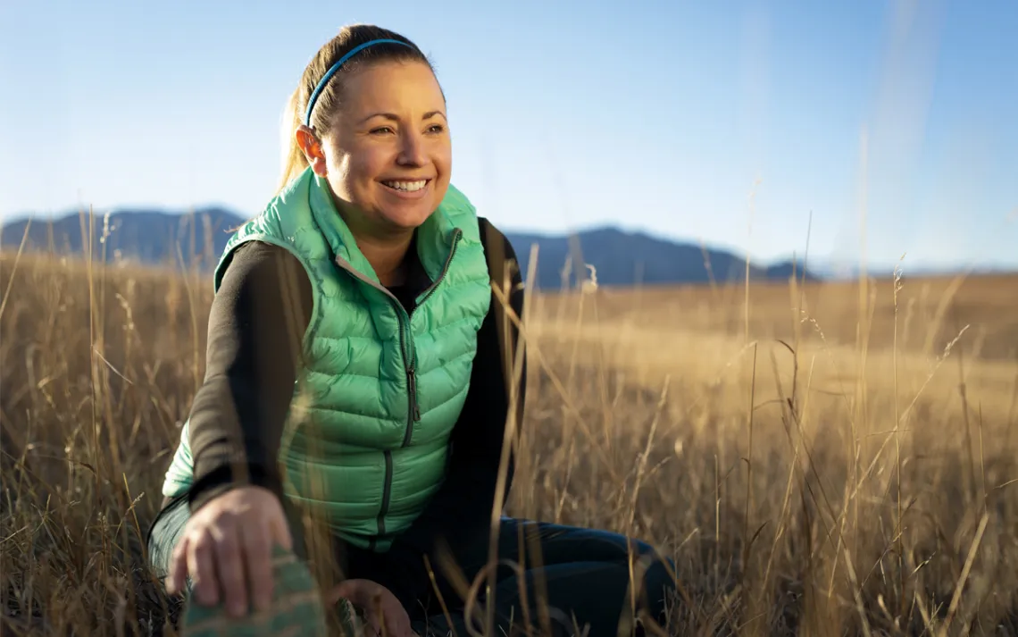 Megan Rast stretches in a field