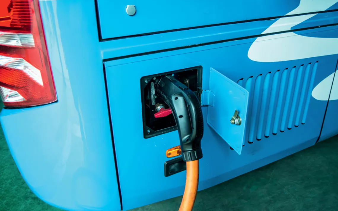 Close-up of a blue EV bus being charged