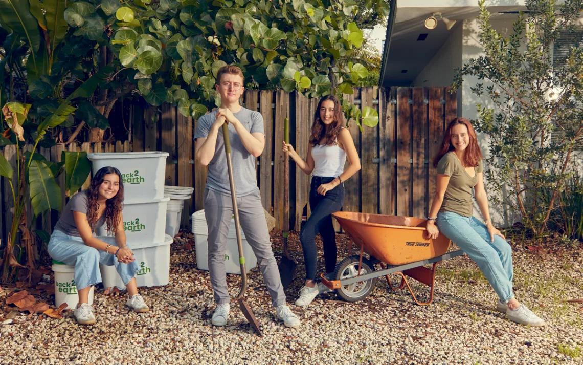 Anna, Ugo, Emma, and Mila Angeletti pose with Back2earth bins, a shovel, and a wheelbarrow.