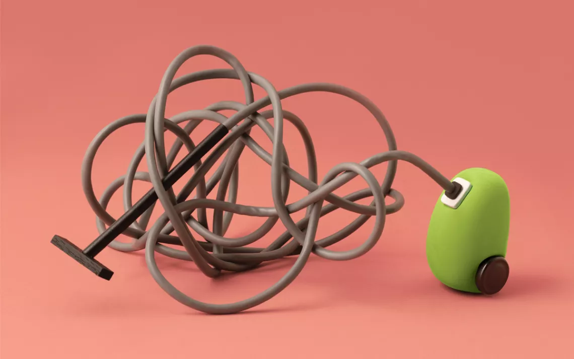A little green vacuum has long cord tied up in knots against a pink-orange background.