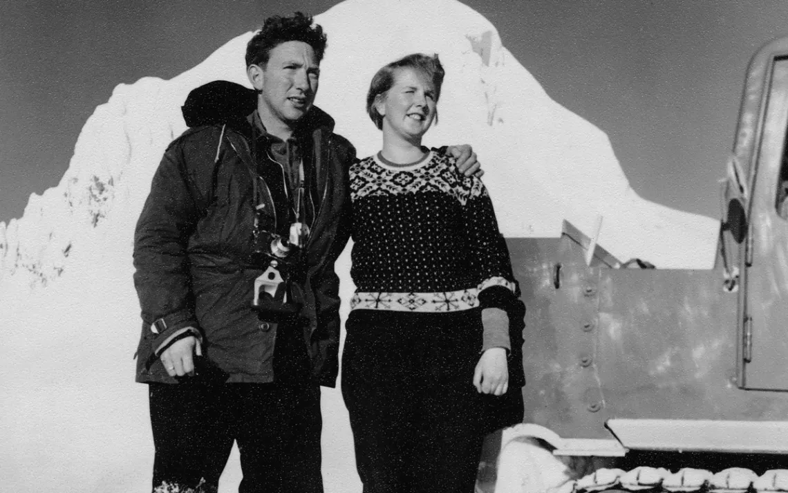 Black and white photo of a man and a woman standing on a glacier in the 1950s, looking dashing. 