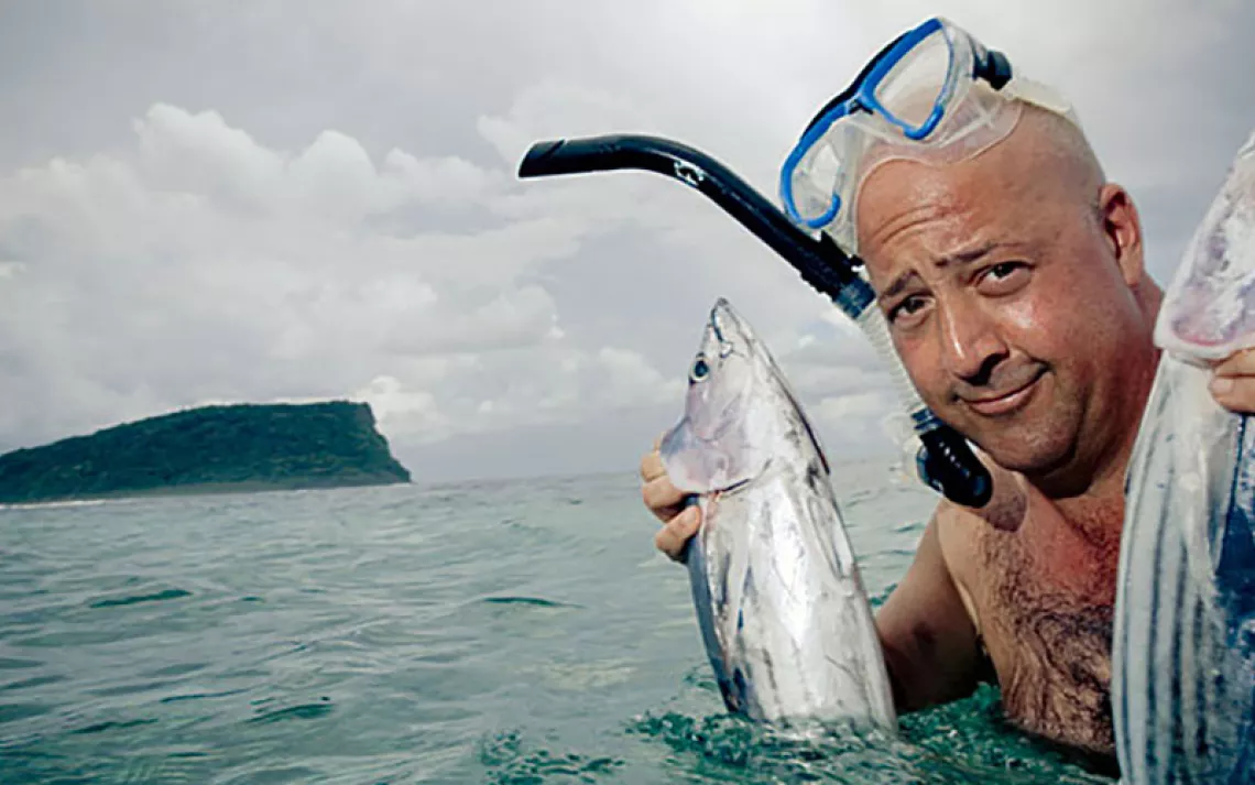 Andrew holds two tuna fish in Samoa. | Courtesy of the Travel Channel