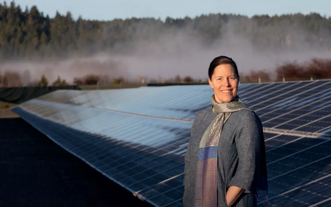 Jana Ganion, sustainability director for Blue Lake Rancheria, stands in front of a solar panel array.