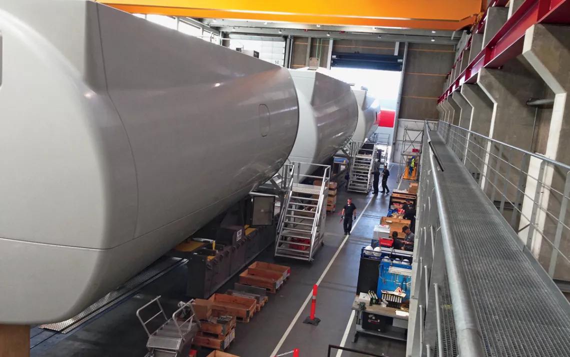 Giant 6-megawatt turbine nacelles move down Siemenss assembly line. The factory is powered by an on-site 1-megawatt turbine.