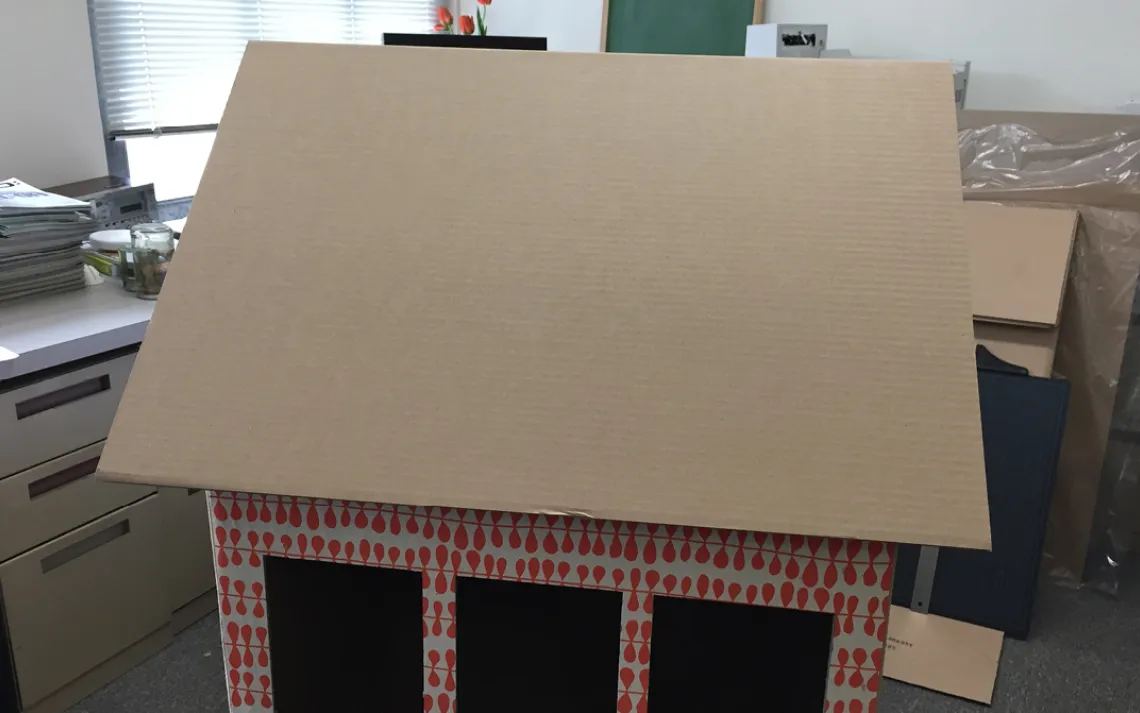 Tape or glue the extra piece of cardboard on top of the front side of the roof.