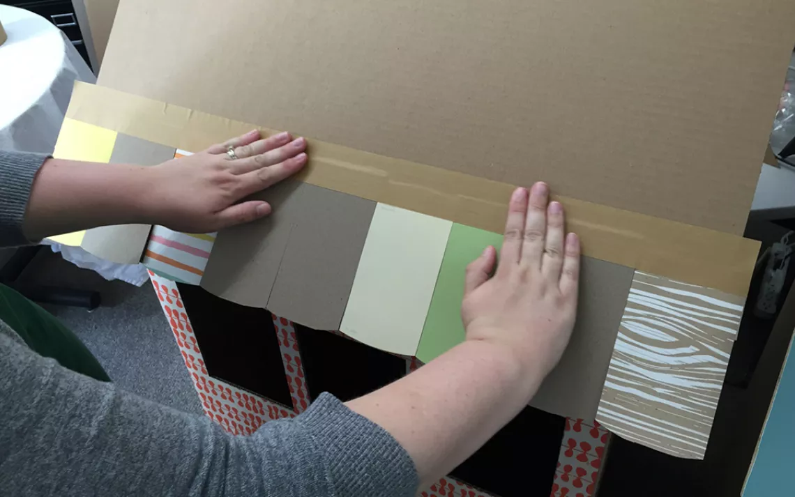 Measure and cut out tiles, then tape or glue them to the roof. 