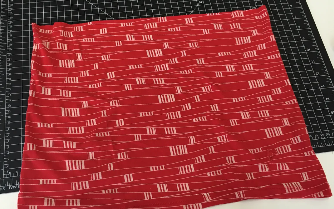 Cut the fabric along the line, removing the sleeves and upper part of the shirt.