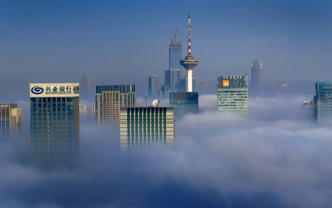 High-rise buildings and skyscrapers are vaguely seen in heavy smog in Shenyang city, northeast China's Liaoning province, 21 November 2014.