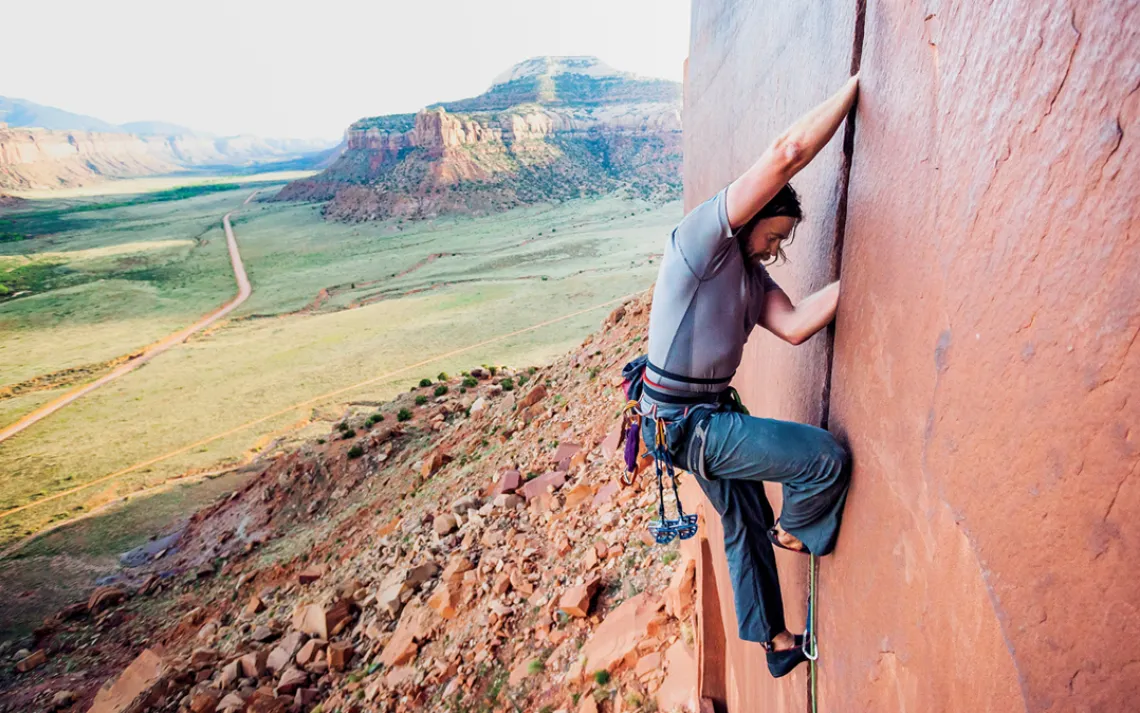 A climber ascends a wall in Indian Creek Canyon, just outside of Canyonlands National Park.