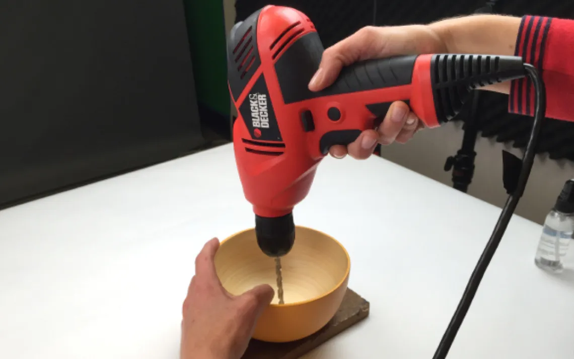 Drill a hole through the center of the bowl wide enough for the carriage bolt to fit through.