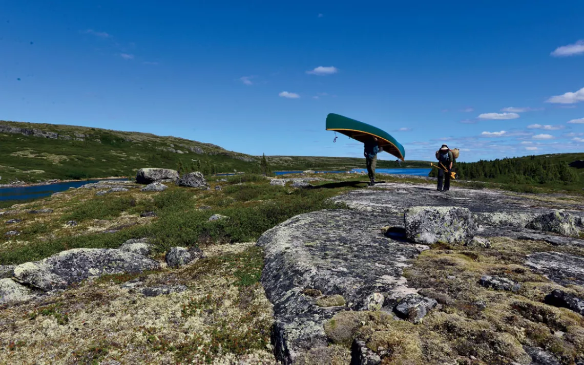 Conor and Kim Mihell portage on the rocky tundra of northern Quebec.