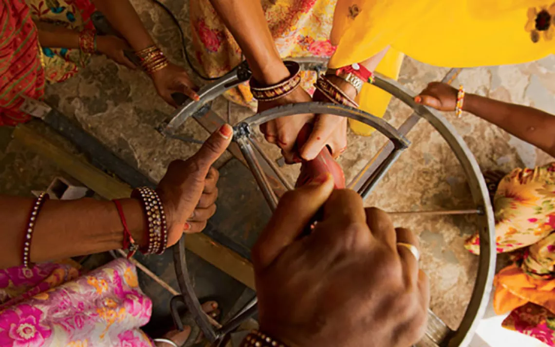 Women repair a solar cooker at India's Barefoot College, which has a six-month program that teaches rural women how to bring solar power to their villages.