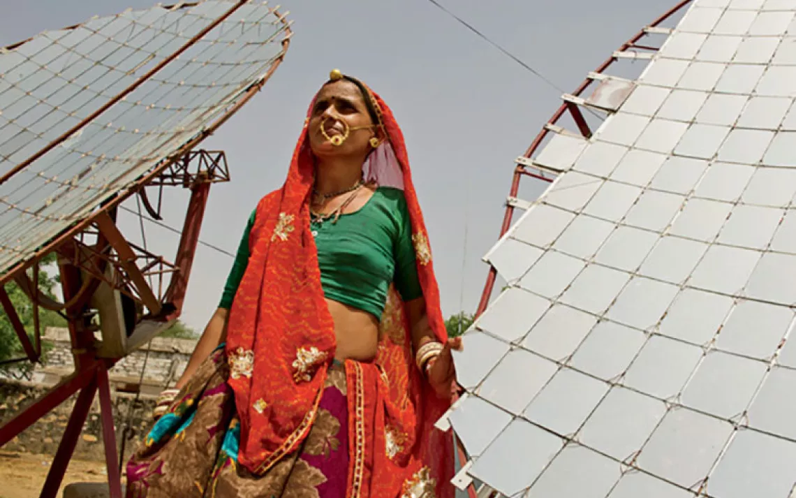 One of the Barefoot College's 200 workers monitors a parabolic solar cooker.