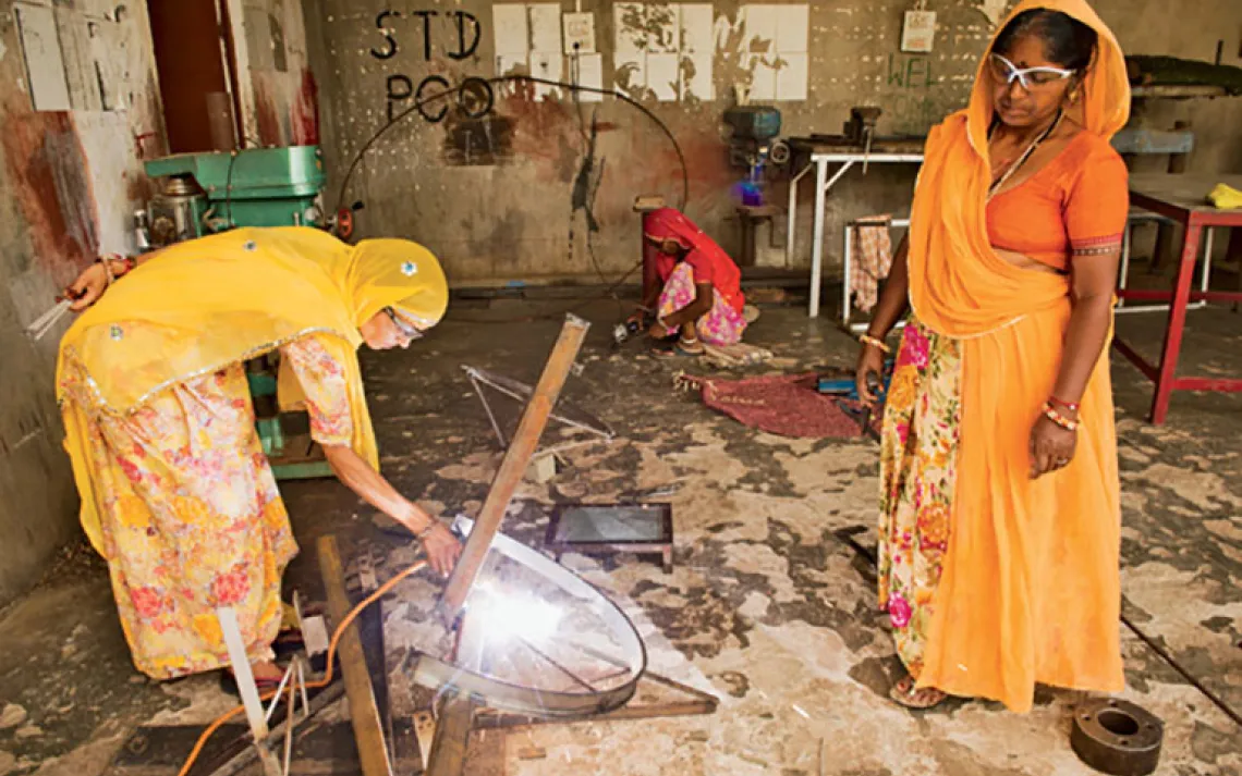 Welding a solar cooker.