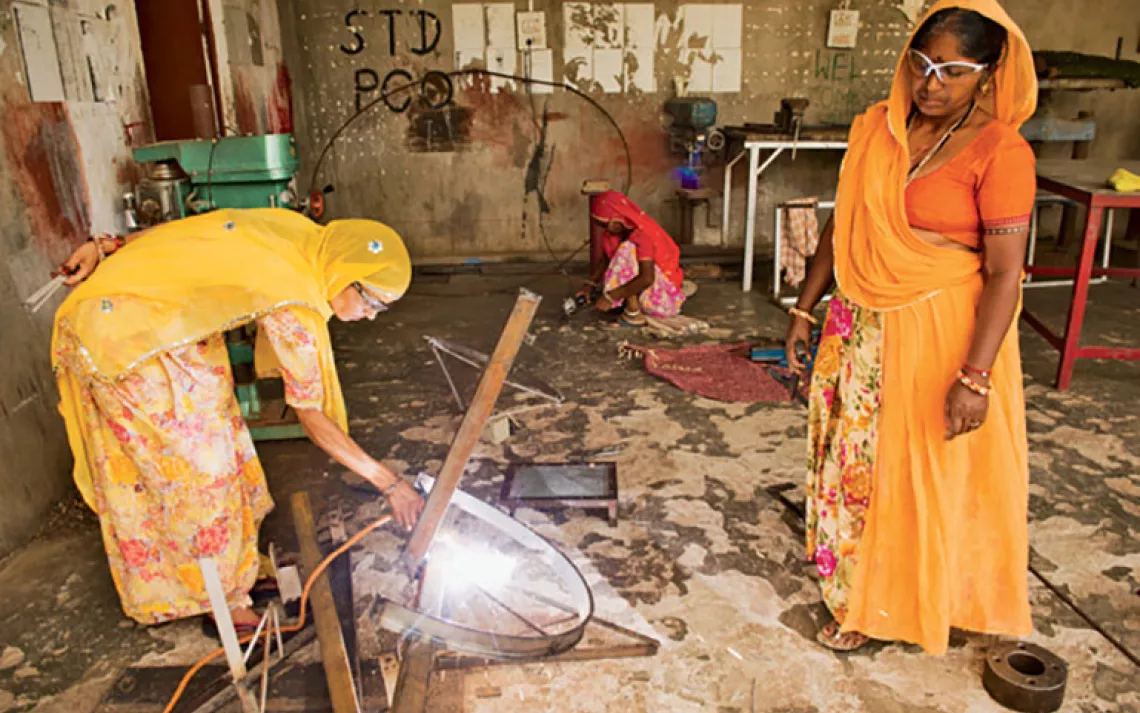 Welding a solar cooker.