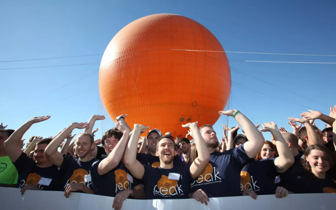 West Virginia University students—wearing T-shirts that say "Preserving Energy with Appalachian Knowledge"—at the 2013 Solar Decathlon at the Orange County Great Park (known for its giant orange balloon).