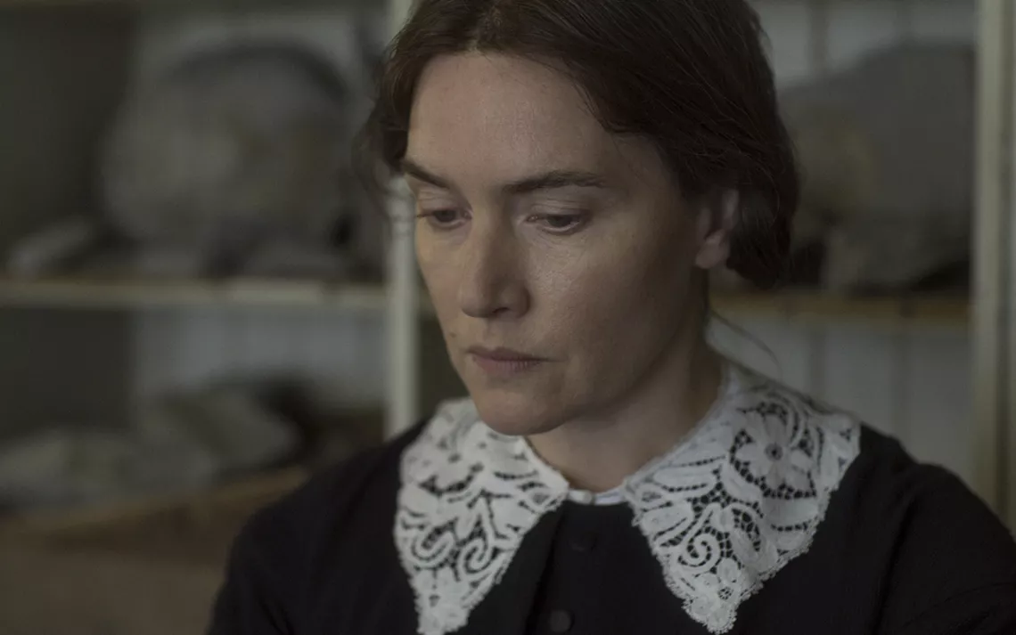 Kate Winslet in a lace collar making a glum face. 