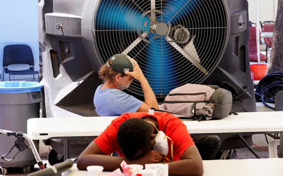 People try to keep cool at the Justa Center, a resource center catering to the older homeless population, as temperatures hit 110-degrees, July 19, 2022, in Phoenix.