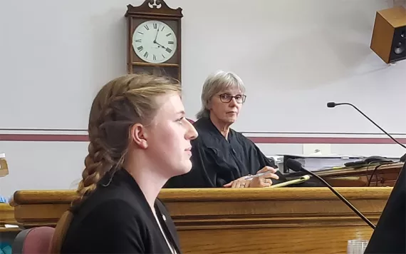 Grace Gibson-Snyder testifies on opening day while Judge Kathy Seeley looks on.