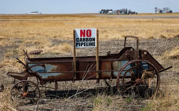 A sign opposing proposed carbon-capture pipelines is seen on a manure spreader