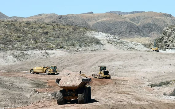 Construction trucks haul and push dirt at the Shafter Mine Project.