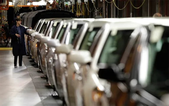 A line worker checks vehicles at the General Motors Hamtramck assembly plant in Hamtramck, Mich.