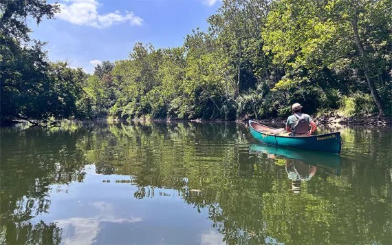 A man paddles a canoe down Indianapolis' White River