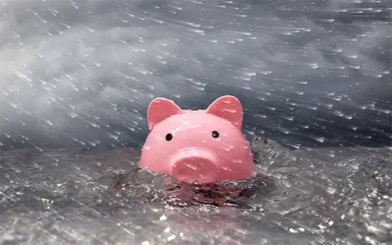 A pink piggy bank drowning in a flood