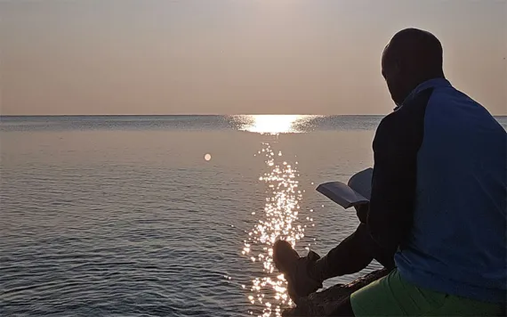 Sherman Neal II, the deputy director of the Sierra Club Military Outdoors campaign and a Marine Corps veteran takes a break from hiking along the shores of Lake Michigan. | Photo courtesy of Sherman Neal II