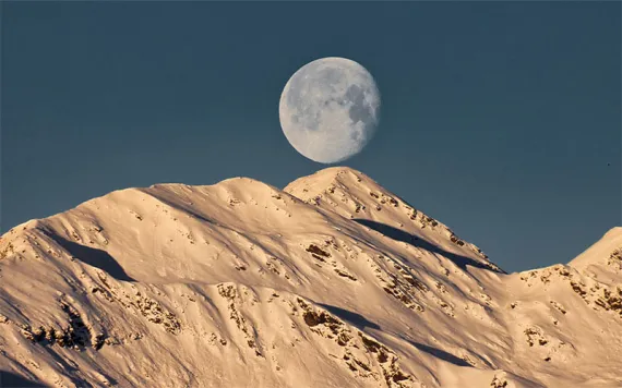 Low angle view of moon over the mountains   
