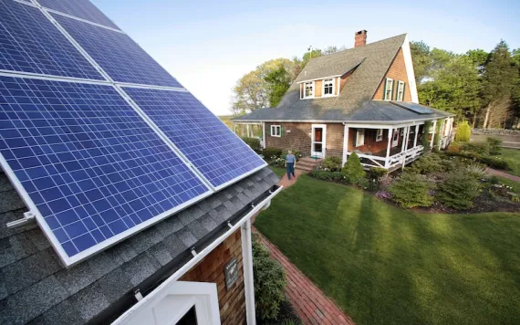 Len Bicknell walks from his house to his garage where his solar energy panels are mounted on the roof in Marshfield, Mass. Renewable energy interests are flexing their newfound power not just with solar panels and wind turbines but in the corridors of the Massachusetts Statehouse.