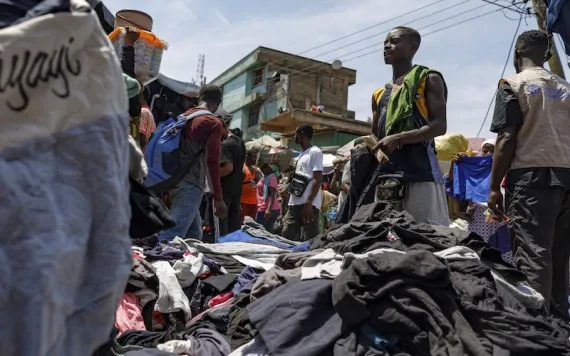 A head porter carries a bale of Second-hand clothes at Kantamanto market, one of the world's largest second-hand clothes markets in Accra, Ghana, Thursday, Oct. 31, 2024. (AP Photo/Misper Apawu) 