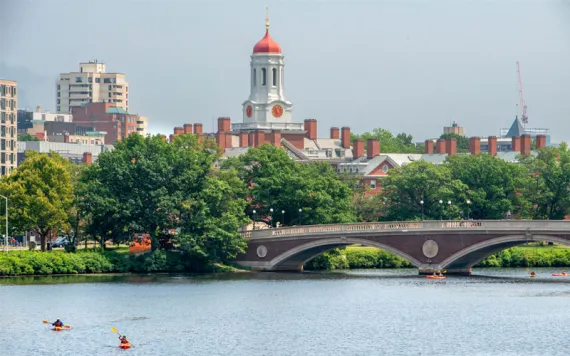 Kayaking under the John W. Weeks Bridge in the Charles River with Harvard University campus in Cambridge, Massachusetts, in the background. 