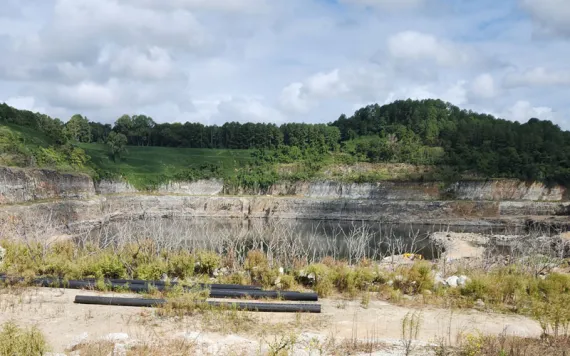The canyon walls surround the Kings Mountain mine with trees and shrubs on the rim.